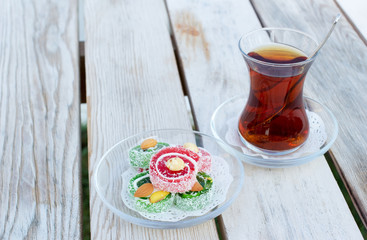 Cup of black Turkish tea and traditional asian sweets.