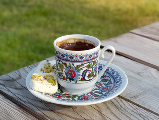 Cup hot black Turkish coffee and traditional sweets.