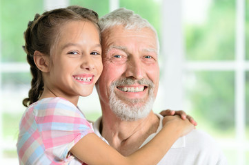 Grandfather with her granddaughter hugging 