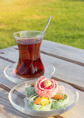 Сup of black Turkish tea and traditional asian sweets.