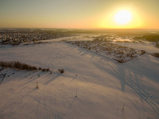 snow-covered field in the rays of the setting sun