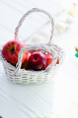 Fototapeta na wymiar Red fresh apples in a white wooden basket