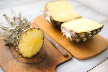 Sliced fresh pineapple on a wooden background in sunlight