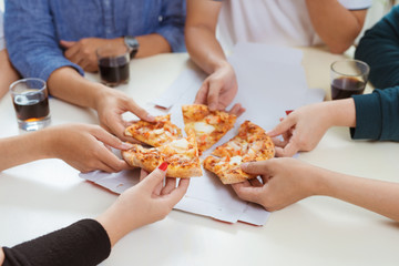 People eat fast food. Friends hands taking slices of pizza