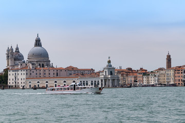 Fototapeta na wymiar Venedig mit Blick auf Kirche Santa Maria della Salute mit Boote und blauen Wolken Himmel