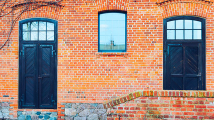 old red brick barn with wooden doors