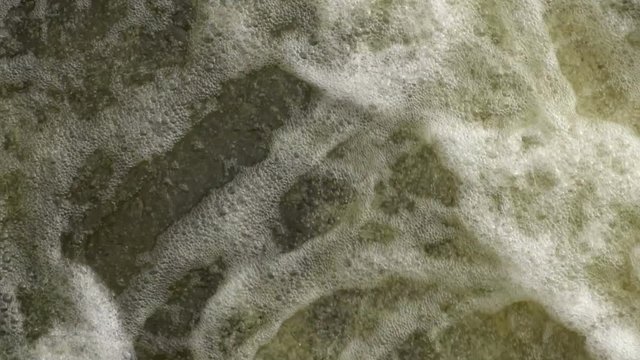 A strong flow of water. Strong stream of water with bubbles. Slow motion