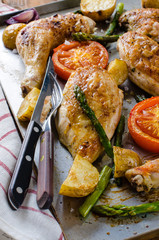 Oven-baked chicken with vegetables on the roasring tray