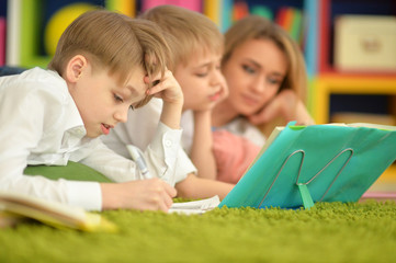 Obraz premium mother and sons doing homework