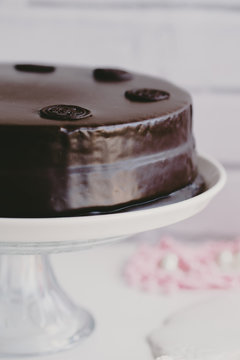 Close-up side view of a chocolate cake with chocolate glaze (sachertorte) on a cakestand