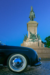 Luxury vintage classic sport car bumper and Monument to Garibaldi in night Rome Italy