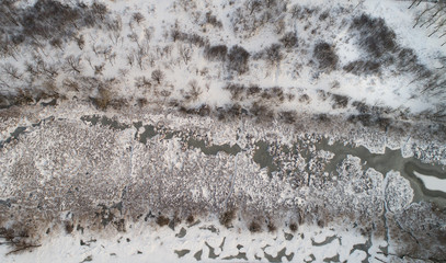 Aerial image of frozen river in forest