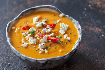Roasted pumpkin and carrot soup with cream and pumpkin seeds