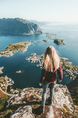 Young woman in Norway standing alone on cliff  mountain lifestyle exploring concept adventure...