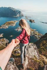 Couple follow holding hands traveling lifestyle on cliff mountain summer vacations outdoor in Norway - obrazy, fototapety, plakaty
