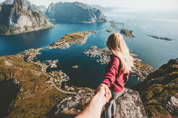 Traveling Couple follow holding hands on cliff mountain in Norway lifestyle concept summer...