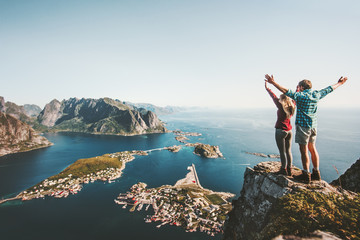 Couple heureux amour et voyage mains levées sur la falaise en Norvège homme et femme voyageurs en famille concept de mode de vie vacances d& 39 été en plein air îles Lofoten