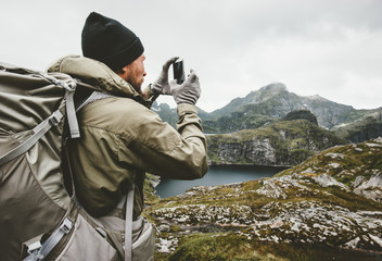 Man traveler checking smartphone gps navigator hiking in mountains Travel survival lifestyle...