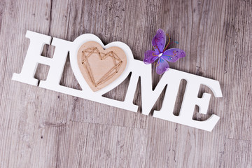 The word Home in white letters with butterfly as decoration
