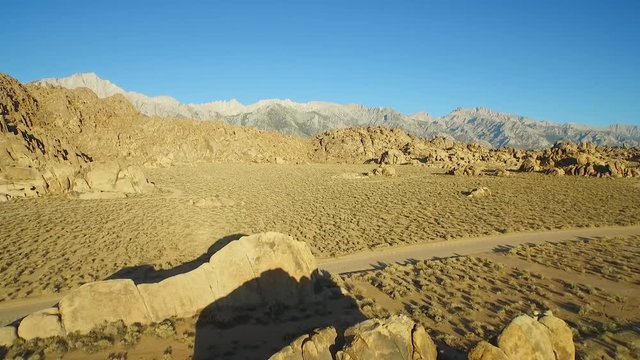 An aerial sunset shot over the Alabama Hills outside Lone Pine California with Mt. Whitney and Sierras background.