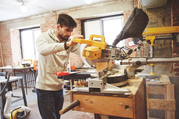 The young carpenter works in a workshop