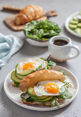 Breakfast with Croissant sandwiches with Fried Egg, Salad Leaves and avocado