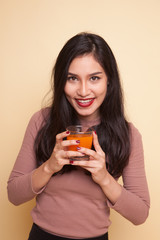 Young Asian woman with dumbbell drink orange juice.