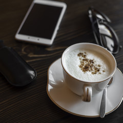 Cup of coffee and phone on the table.