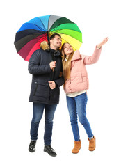 Young romantic couple with colorful umbrella on white background