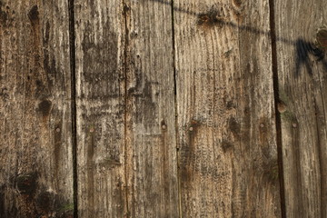 Old plank wooden wall background. The texture of old wood. Weathered piece of wood.