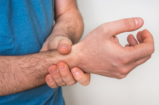 Man with wrist pain is holding his aching hand