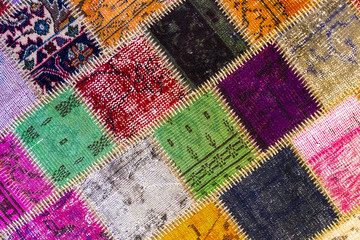Background of an old worn carpet sewn with thick threads. 