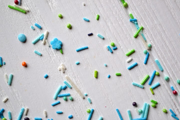 Colorful sugar on the table. Bright sweet powder for cake on the white wooden background. Beautiful abstract background. 