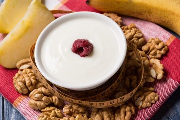 yogurt in a pial decorated with raspberries, nuts and fruits, concept of healthy eating