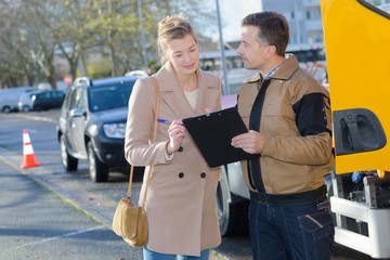 tow truck driver talking with female client