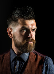 Bearded man in shirt and vintage suede waistcoat. Side view portrait of attractive brutal bearded guy. Advertising barbershop concept.