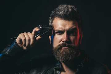 Rock-singer. Talented bearded singer with microphone. Life style concept - handsome man with beard and mustache in black leather jacket holds microphone. Emotional portrait attractive rock star man.