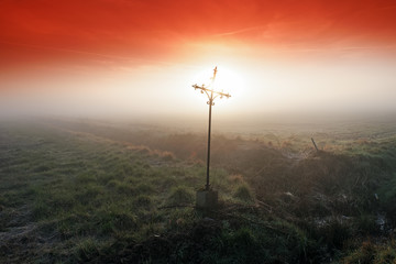 Obraz premium Wrought iron cross in misty field. Le Coudray-Montceaux village