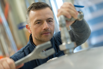 factory man worker measuring detail with vernier caliper at workshop