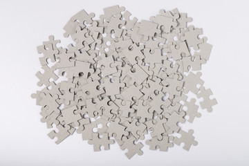 Heap Of Jigsaw Puzzles Grey Color On White Paper Background Top View. Assembly Of Puzzles....