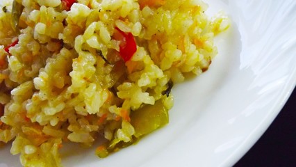 Risotto with vegetables on a white plate.