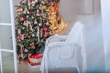 Christmas Tree and Christmas gift boxes in the interior with a fireplace.