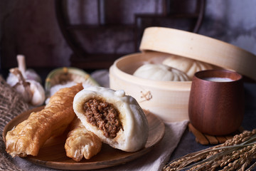 Obraz na płótnie Canvas Chinese breakfast: Steamed buns (Baozi), fried breadsticks (yout