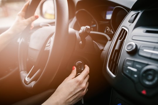 Young Woman Starting Car Engine With Key