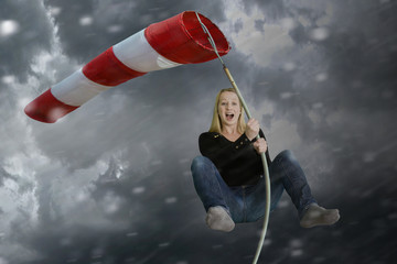 Frau klammert sich bei schlechtem Wetter an einen Windsack