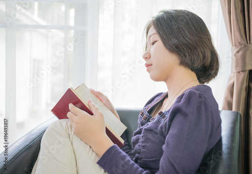 Young Asian Woman Short Hair Read A Book In Living Room Stock