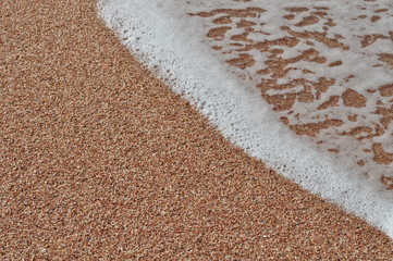 Sea foam on a sandy beach