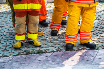 fireman standing in row with fire fighting protection suit and equipment standby for operation