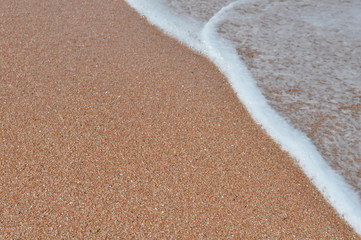 Sea foam on the sandy beach