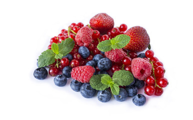 Mix berries and isolated on a white. Ripe blueberries, raspberries, red currants and strawberries with mint. Berries and fruits with copy space for text. 